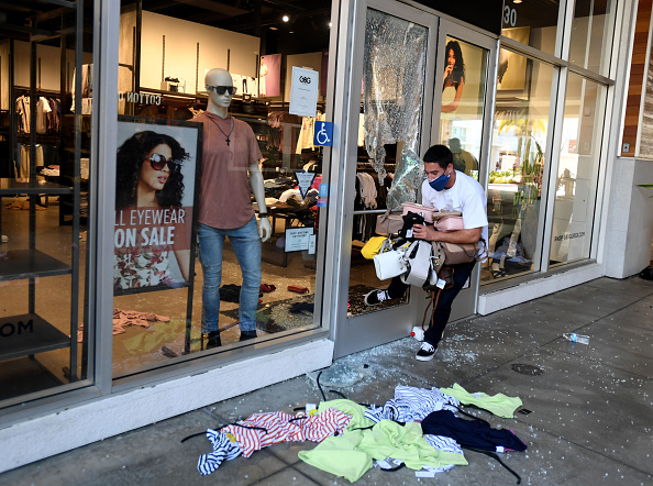 A looter exits the Guess store