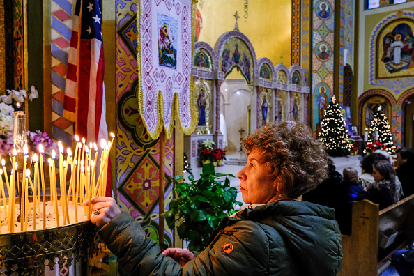 A woman lights candles during a mass