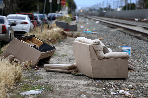 Discarded couches and trash along train tracks