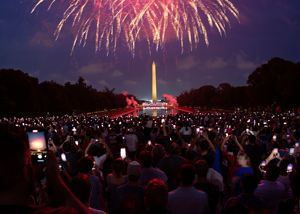 Attendees watch the Independence Day fireworks display along the National Mall in Washington, DC. Attendees watch the Independence Day fireworks display along the National Mall in Washington, DC.