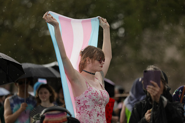 A person holds a transgender pride flag