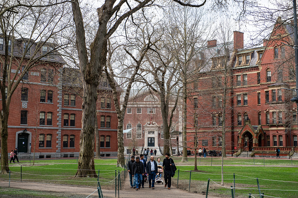People walk through Harvard Yard on the Harvard University campus in Cambridge, Massachussetts.