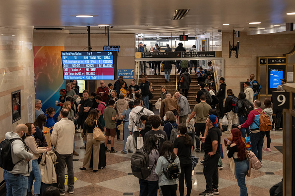 People crowd as they wait for trains inside Penn Station in New York City. 