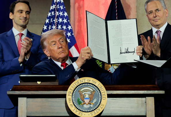 President Donald Trump displays a signed executive order