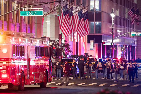 Police officers gather in the street as they respond to the shooting in Midtown Manhattan