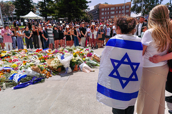 Members of the public gather at a memorial outside the Bondi Pavilion at Bondi Beach