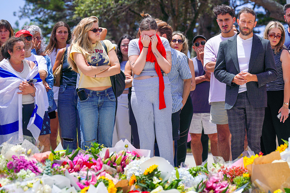 People mourn at a public memorial outside the Bondi Pavilion at Bondi Beach