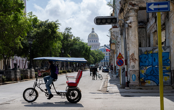 A pedicab drives past a traffic light that is out due to a power cut in Havana
