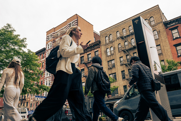 People walk past an apartment building in New York City