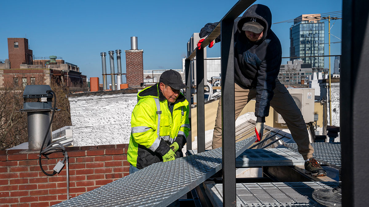 Steel grates are unloaded and positioned for a new rooftop apartment in New York City. Steel grates are unloaded and positioned for a new rooftop apartment in New York City.