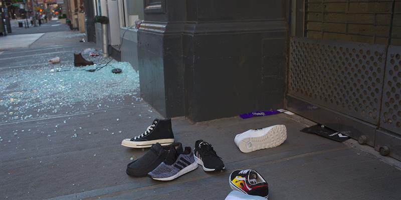 Stolen sneakers litter the sidewalk as evidence of widespread vandalism and looting appears in downtown Manhattan
