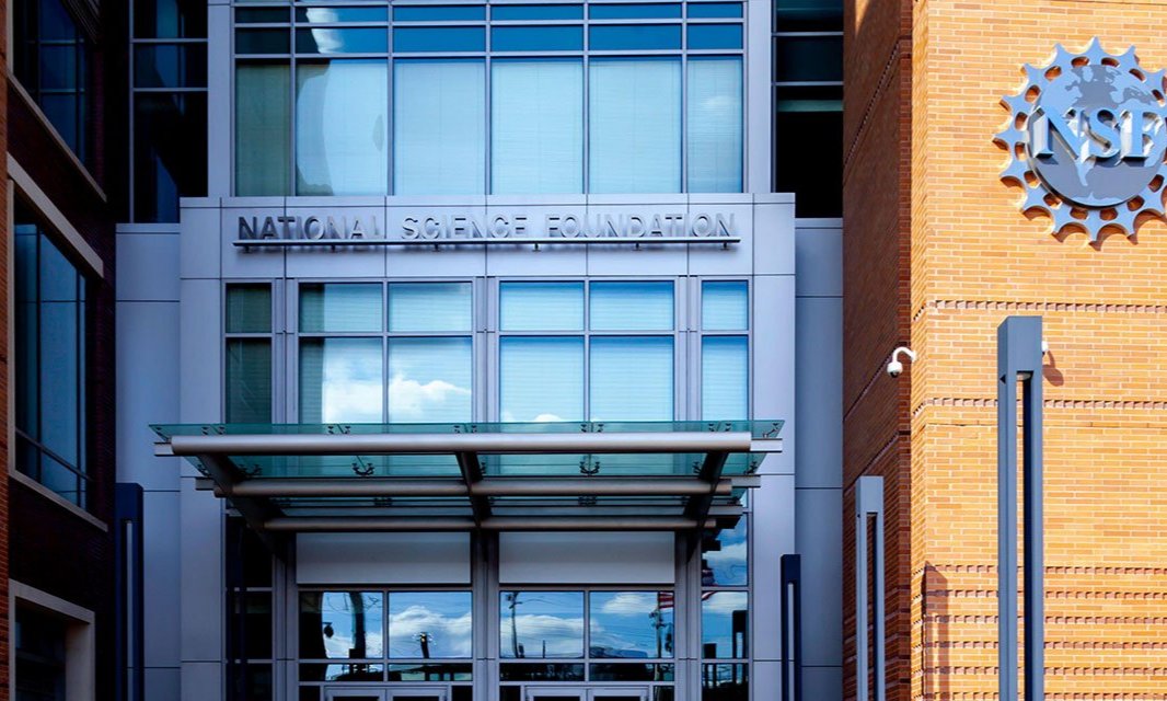 A man takes a photo of a mural of Luigi Mangione