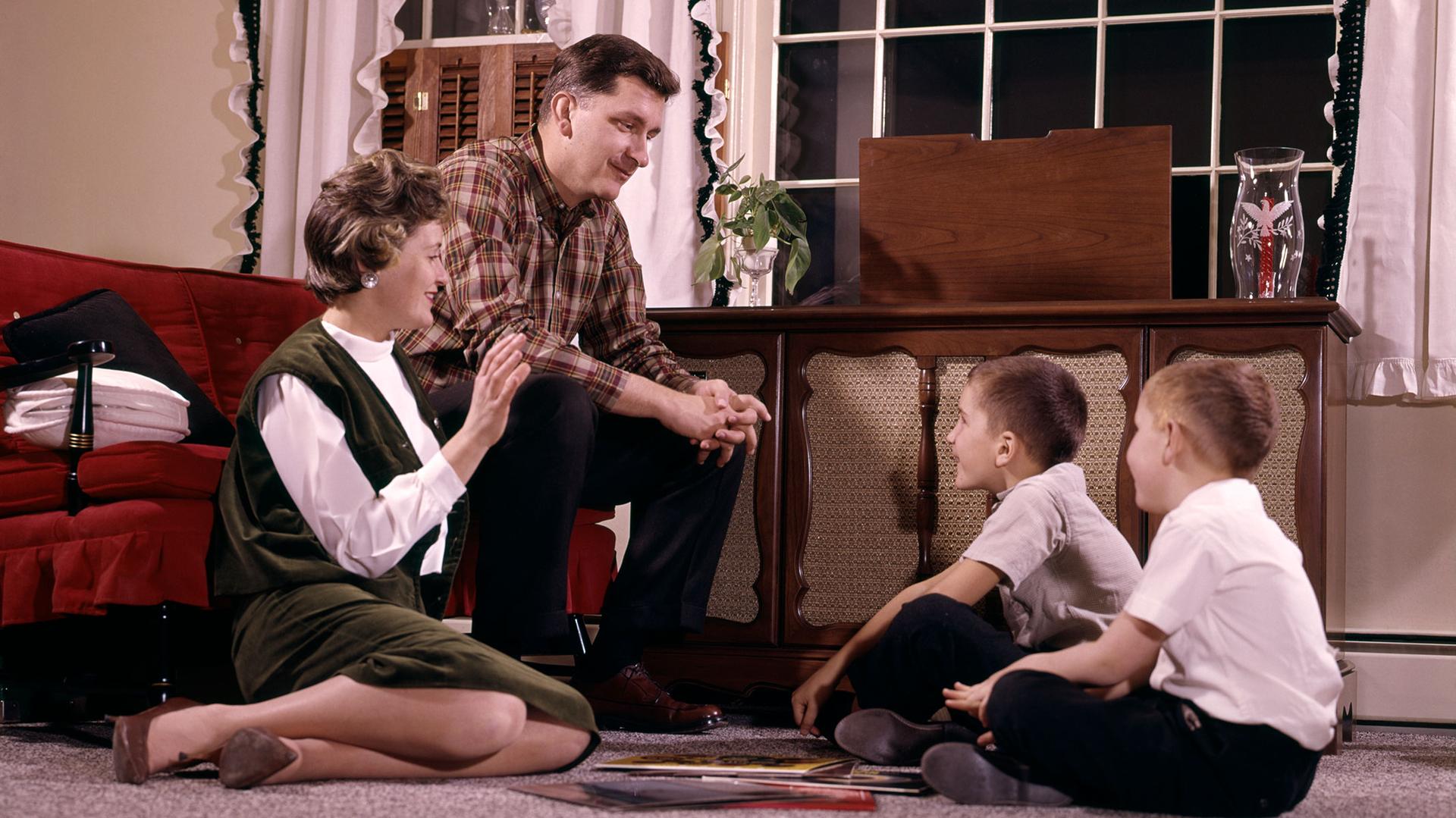 Family gathered around a record player 
