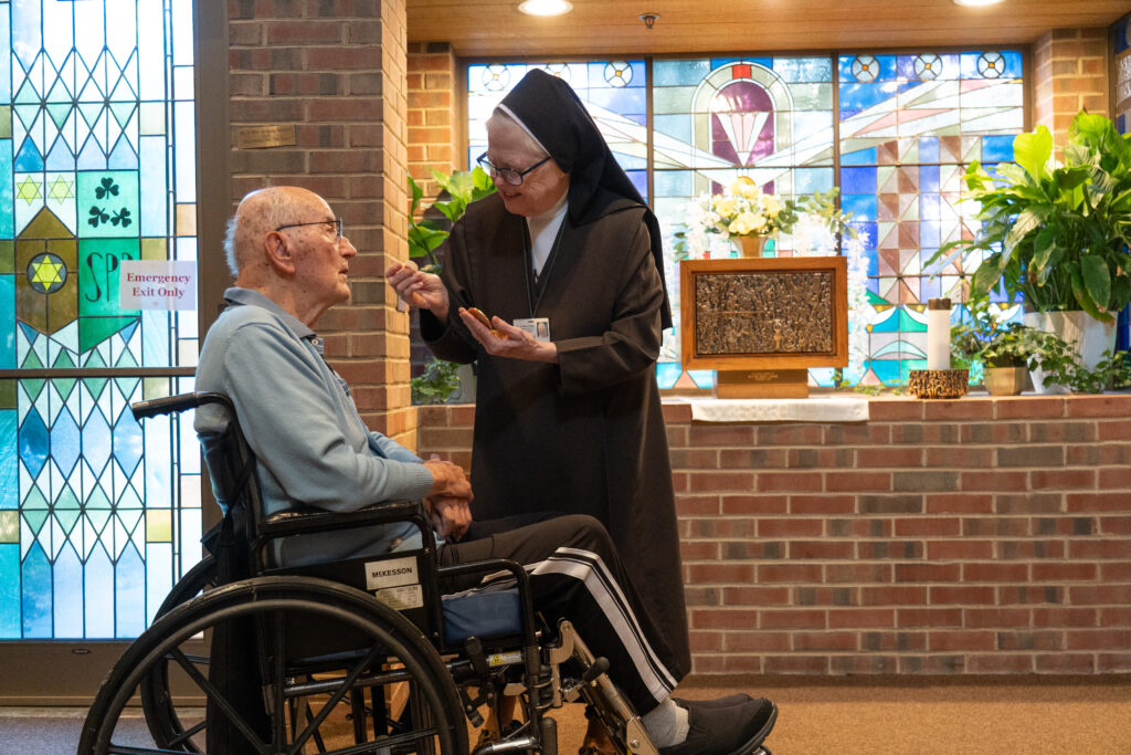 Nun with elderly man in wheelchair