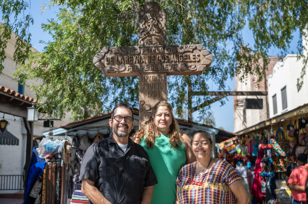 Man and two women in front of Olvera Street cross